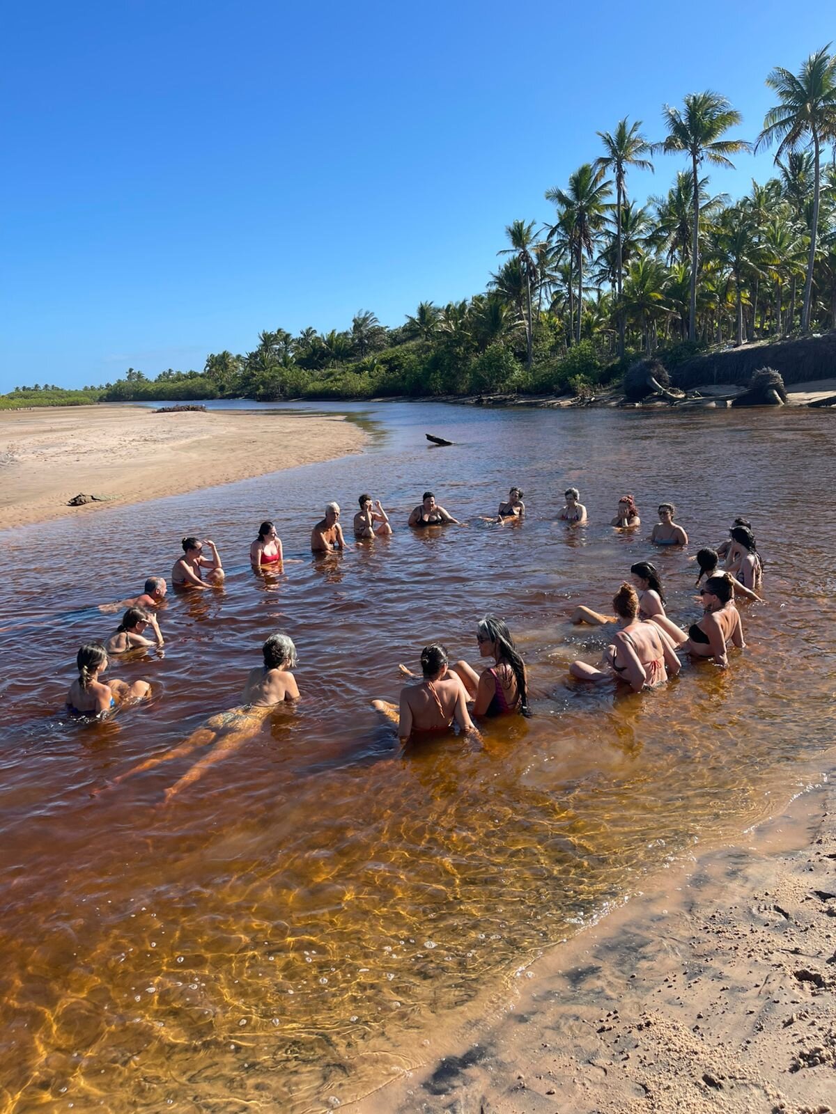 Círculo de pessoas no rio ao entardecer